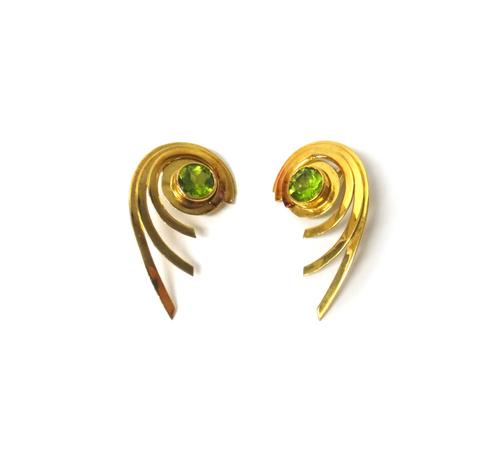A pair of 18ct gold and peridot set single stone earclips, each in a swirling design, collet set with the circular cut peridot at the centre, maker's