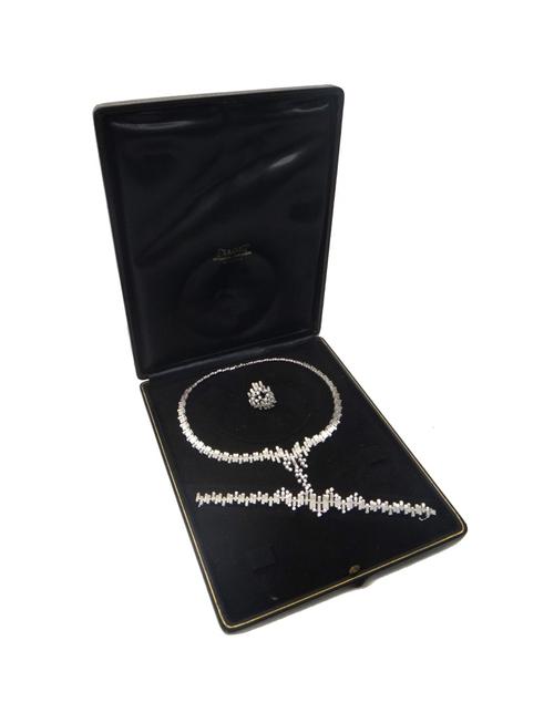 A white gold and diamond set demi parure, comprising; a collar necklace, a bracelet and a ring, each in a rustic abstract design, having a textured fi