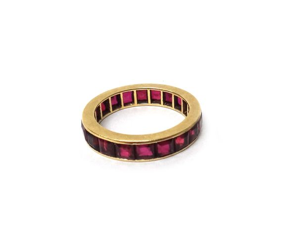 A gold and ruby set full eternity ring, mounted with square emerald cut rubies, ring size N and a half, gross weight 4.4 gms.
