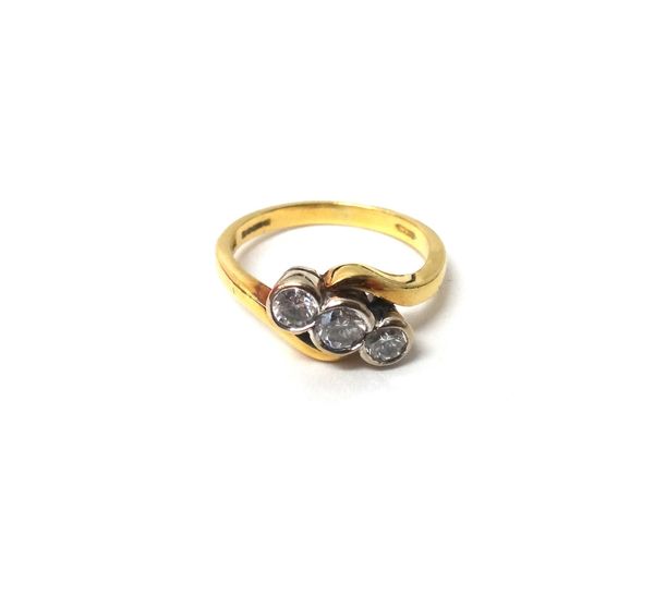 An 18ct gold and diamond set three stone ring, collet set with a row of circular cut diamonds, in a crossover design, ring size K and a half, with a c