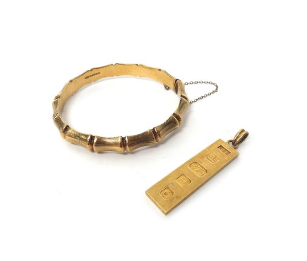 A 9ct gold rectangular ingot pendant and a 9ct gold oval hinged bangle, decorated with bamboo, combined gross weight 24,5 gms, (2).