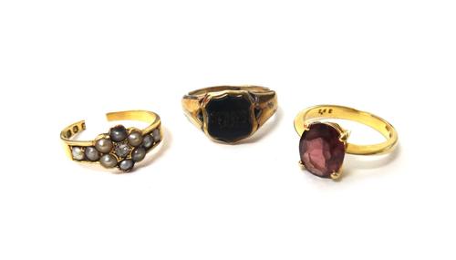 A gold ring, claw set with an oval cut garnet, detailed 750 18K, an 18ct gold, diamond and seed pearl set ring, London 1886 (the shank cut) and a bloo