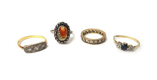 A gold and diamond set ring, mounted with three principal circular cut diamonds and otherwise mounted with eight smaller circular cut diamonds at inte