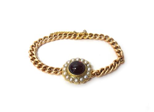 A gold, half pearl and carbuncle garnet set bracelet, mounted with the carbuncle garnet at the centre, within a surround of half pearls, the curb link