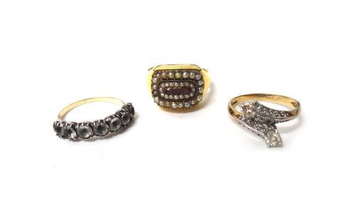 A 9ct gold and diamond set ring, in a crossover design, mounted with two principal circular cut diamonds, an 18ct gold, seed pearl and garnet set ring