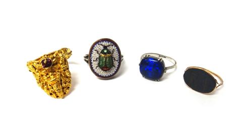 A gold ring, mounted with an oval agate intaglio, the later mount with a wirework shank, an Oriental gold and red gem set ring, with a Deity motif, an