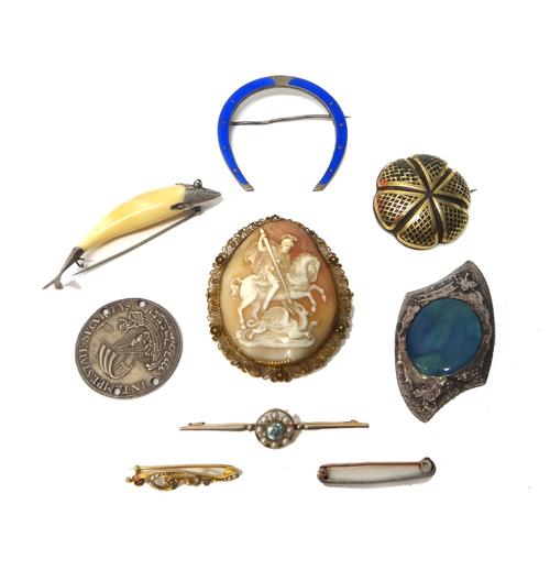A gold filigree mounted oval shell cameo brooch, carved as St George slaying the dragon, mid 19th century, a pique tortoiseshell brooch, a blue zircon
