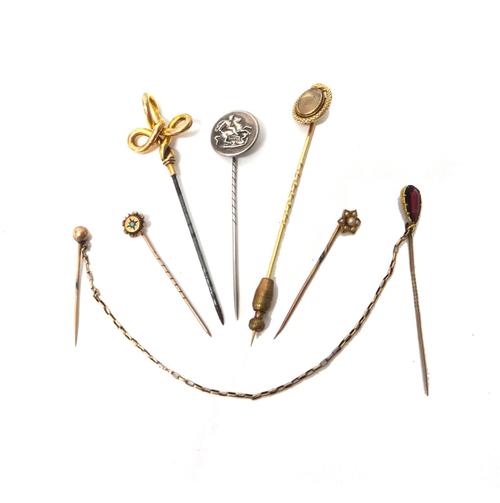 A Victorian gold stick pin, glazed with an oval hair locket compartment at the centre, within a serpentine surround, detailed to the back, LIELA 1854