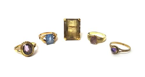A gold ring, claw set with a large rectangular step cut smoky quartz, a 9ct gold ring, mounted with an oval cut amethyst, a gold ring, claw set with a