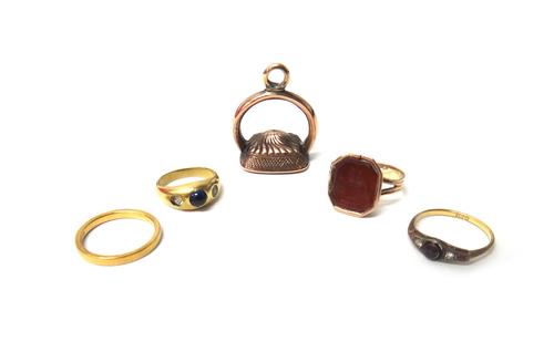 A gold and cornelian set intaglio ring, carved as two doves, a gold wedding ring detailed 750, a gold, diamond and garnet set ring and a gold, blue an