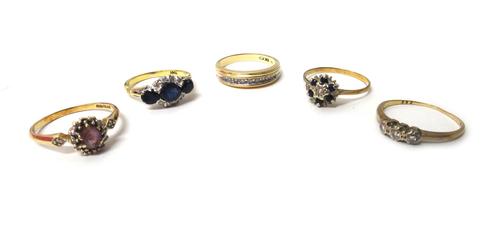 A gold ring, mounted with three oval cut sapphires and with two curved rows of four circular cut diamonds, detailed 18 CT, a gold and diamond set half