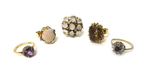A gold ring, claw set with an oval opal between two small circular cut diamonds, a 9ct gold, sapphire and diamond set oval cluster ring, a gold and mo