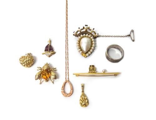 A gold and cultured pearl bar brooch, designed as an owl, with red gem set eyes seated on a bar, a 9ct gold heart shaped pendant, two further pendants
