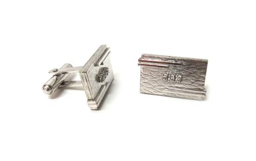 A pair of diamond set dress cufflinks, each rectangular front panel mounted with a row of three circular cut diamonds at the centre, otherwise having
