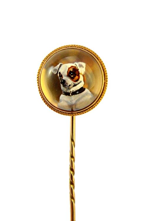 A Victorian gold mounted reverse painted intaglio stick pin, decorated with the head of a small white and brown dog. Illustrated