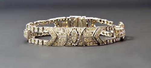 A platinum and diamond set bracelet, in a geometric twin bar and panel shaped Art Deco design, mounted with the principal marquise diamond at the cent