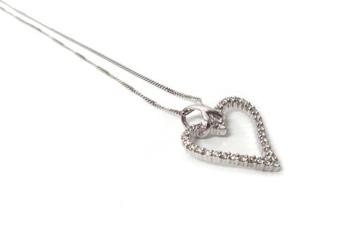 A white gold and diamond set pendant, in a open heart shaped design, mounted with circular cut diamonds, detailed 14K 585, with a 9ct white gold neckc