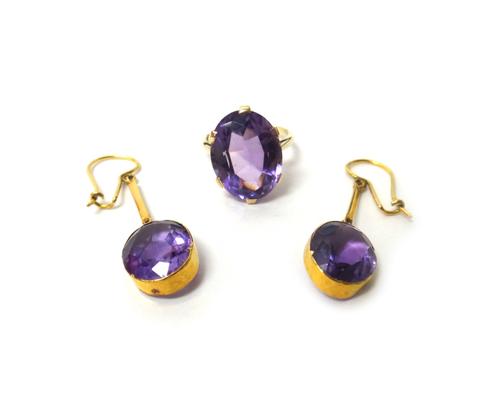 A gold ring, claw set with an oval cut amethyst, ring size K and a pair of amethyst set single stone pendant earrings, each mounted with an oval cut a