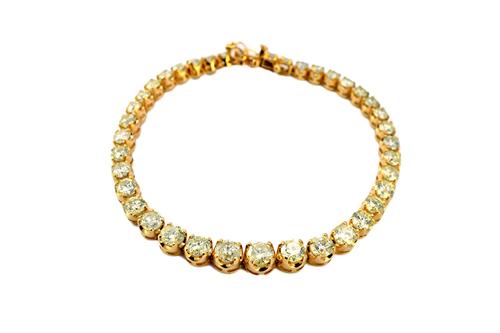 A gold and diamond set line bracelet, claw set with a row of circular cut diamonds, graduating in size to the centre stone, on a snap clasp, detailed