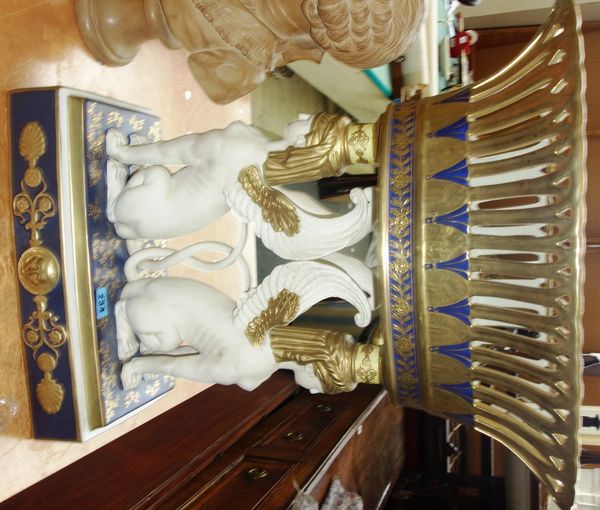 A large 20th century Egyptian revival ceramic centrepiece, with a pierced gilt decorated bowl, over a pair of sphinx supports.