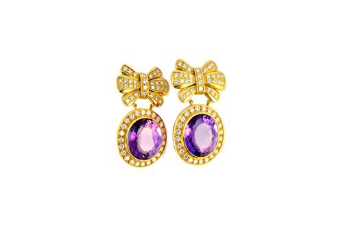 A pair of gold, amethyst and diamond set pendant earrings, each oval drop mounted with an oval cut amethyst at the centre, within a surround of circul