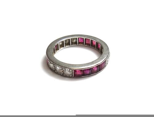 A gold, enamelled and seed pearl set mourning ring, glazed with a circular hair locket compartment to the centre, within a surround of seed pearls, be