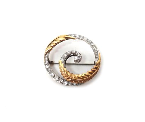 A gold and diamond set circular brooch,decorated with spray motifs, mounted with circular cut diamonds, gross weight 6.5 gms.