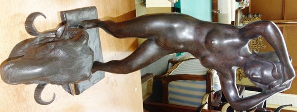 A 20th century bronze figure of a nude female wearing heels, signed 'K. Gibram' and a metal ram's head, (2).