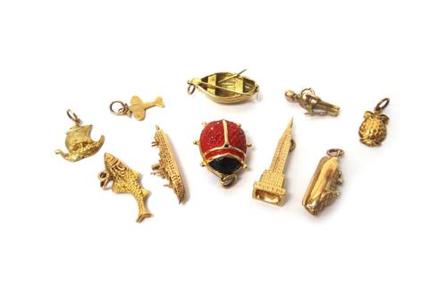 Ten gold charms, comprising; four ships and boats, a fish, a ladybird, a pineapple, an aeroplane, a soldier and a building, various carats, combined g