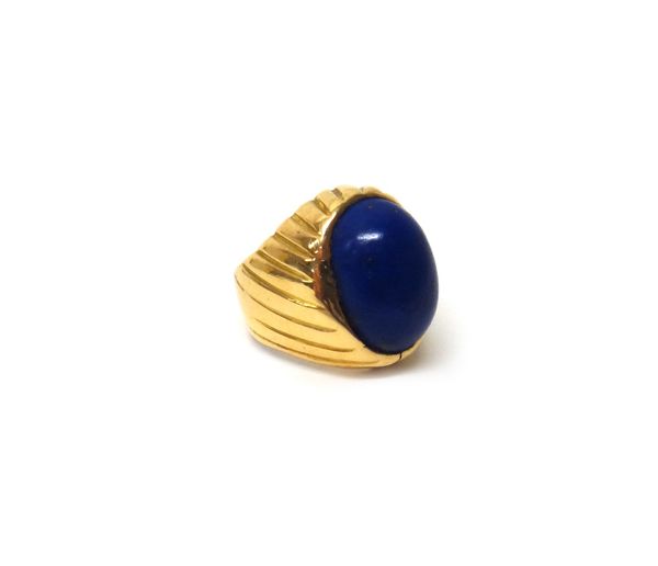 A gold and lapis lazuli set signet style ring, mounted with an oval lapis lazuli between ridged slanting shoulders, indistinctly marked 750, ring size