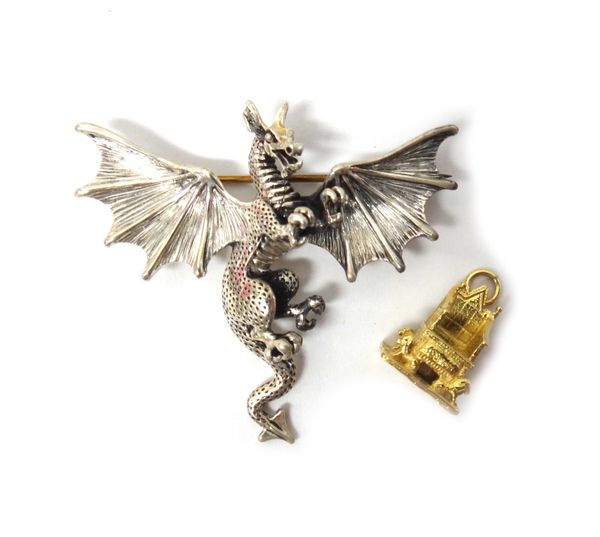 An 18ct gold charm, designed as The Coronation Chair 1953, weight 4.6gms and a silver brooch designed as a dragon by Lexi Dick Jeweller, with a box.