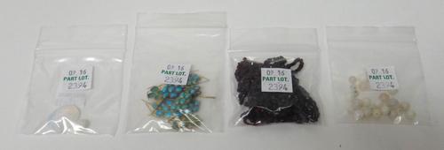 A quantity of unmounted lozenge shaped jades, a garnet bead necklace, five turquoise set motifs including three designed as ears of wheat, a quantity
