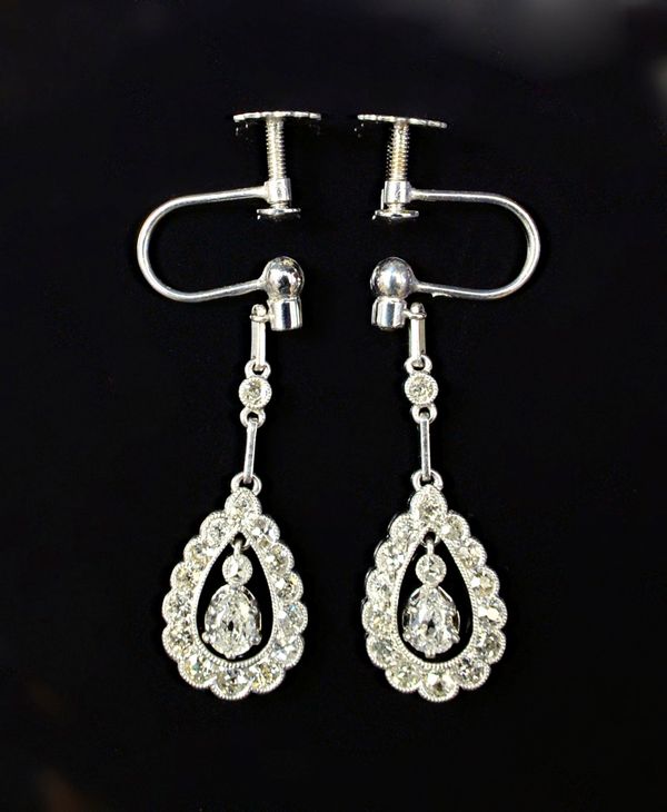 A pair of white gold and diamond set pendant earrings, each with a pear shaped drop, the centre claw set with a pear shaped diamond and with a rose cu