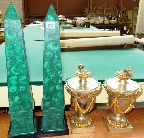 A pair of 20th century faux malachite obelisks and a pair of silver and gilt painted wooden urns, (4).