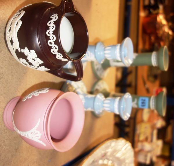 A group of Wedgwood Jasperware including a pair of green candlesticks, a pair of blue candlesticks, a pink vase and a black jug, (qty).