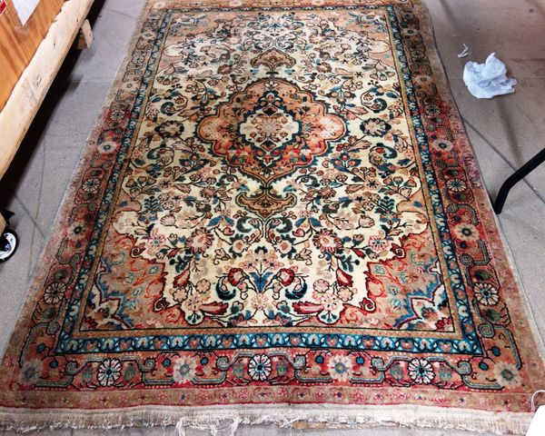 A Sarough rug, Persian, the washed ivory field with a madder medallion, matching spandrels, floral sprays; a madder rosette and leaf border, 210cm x 1