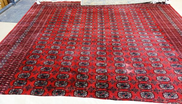 A Pakistan Bokhara carpet, the madder field with nine columns of boteh motifs, various minor borders, 416cm x 292cm together with a Khamseh rug. South