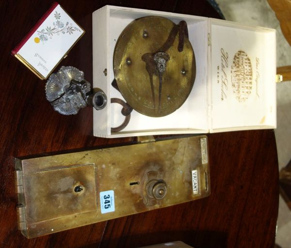 A 20th century brass coin operated toilet door lock and a brass balance scale.