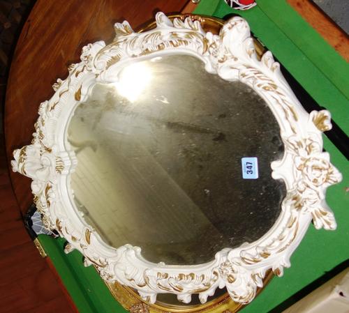 A 20th century oval cream and gilt wall mirror.