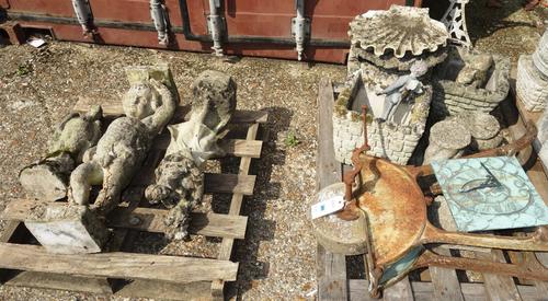 A wrought iron knife sharpening wheel, a sundial plate and assorted figural stone ornaments. (qty)