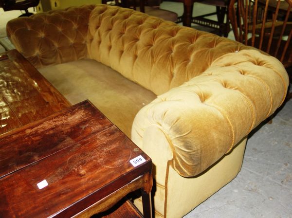 A yellow upholstered button back Chesterfield sofa.