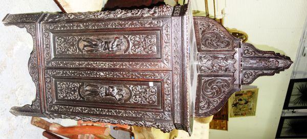 A profusely carved oak corner cabinet with galleried back.