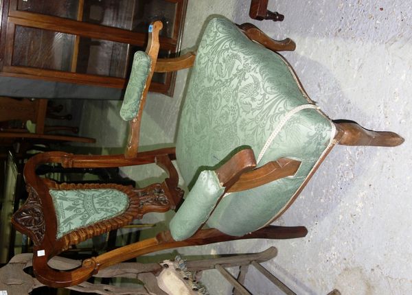 A pair of Edwardian walnut framed green upholstered armchairs.