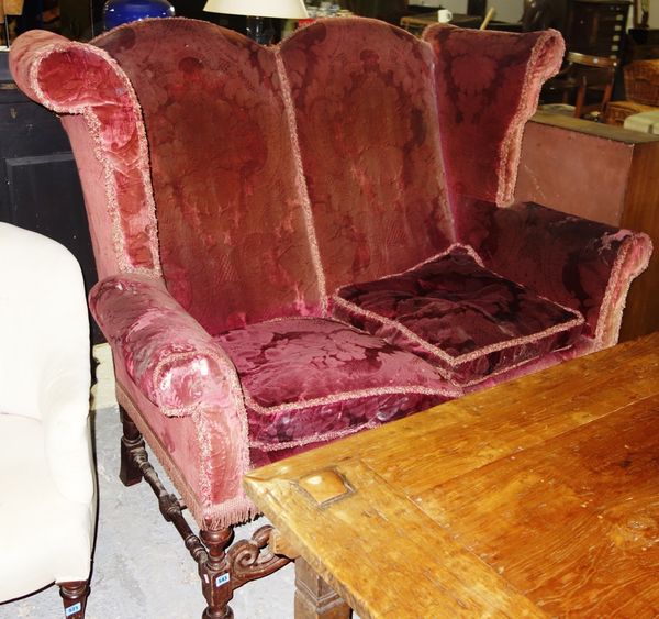 A 19th century wing back red upholstered sofa on mahogany supports.