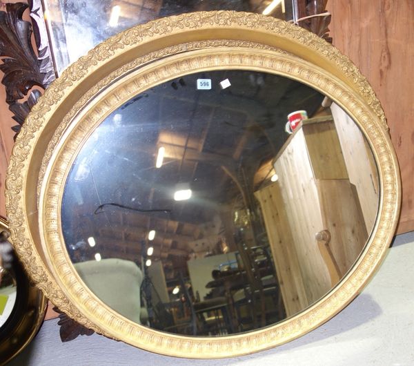 A large gilt framed oval mirror.