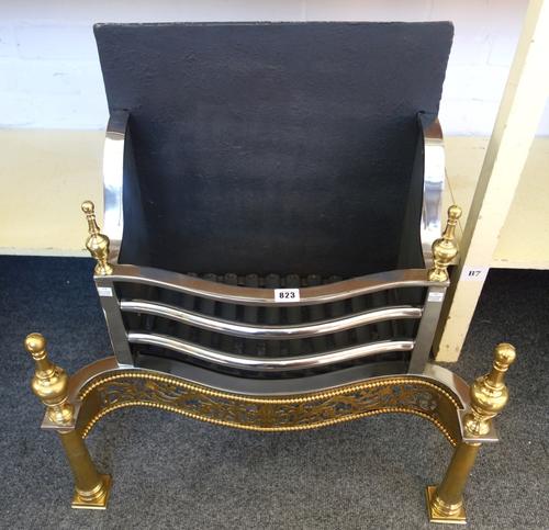 An 18th century style steel and brass fire basket, with pierced serpentine front and turned finials, 65cm wide.