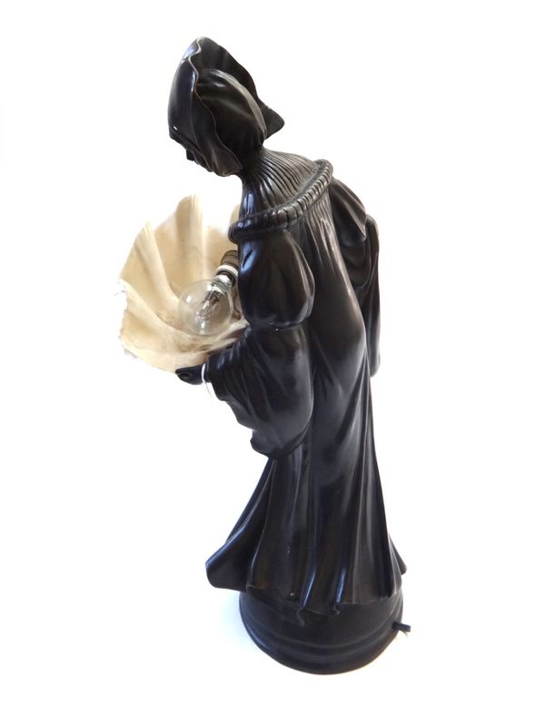 An Art Deco style bronze figural lamp, 20th century, modelled as a woman in a bonnet and long flowing dress, the shade formed as a clam shell, raised