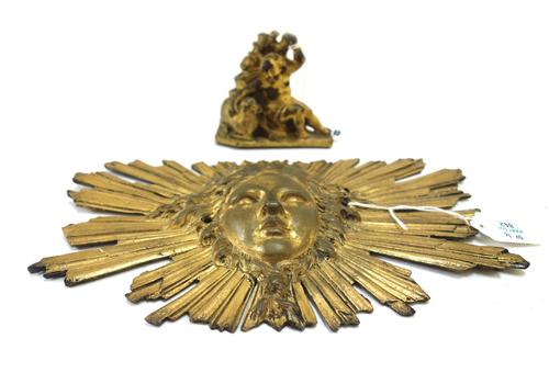An 18th century gilt bronze model of a putto infant St John and lamb, 9cm wide, and a French gilt bronze face mask embellishment. (2)