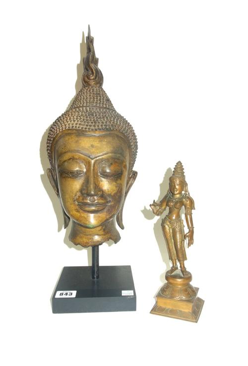 A 19th century Indian patinated bronze figure of Shiva atop a lotus petal, on an incised square base, 23cm high, and a South Eastern bronze head of Bu