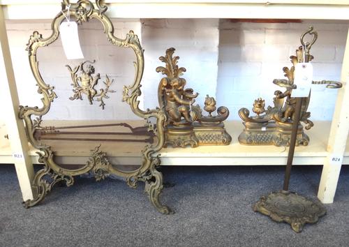 A pair of Victorian gilt bronze fire chenets, each modelled and cast with a Cupid figure warming his hand over a flaming urn, 38cm high, together with